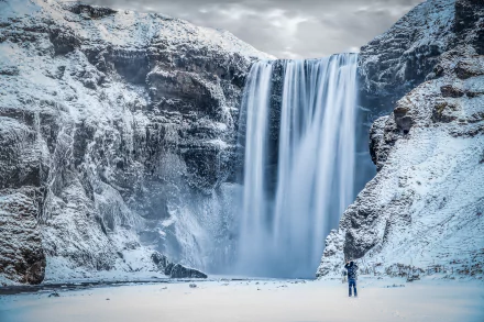 A stunning view of Skógafoss waterfall in Iceland, surrounded by winter snow, showcasing the beauty of arctic nature in breathtaking 4K Ultra HD quality.