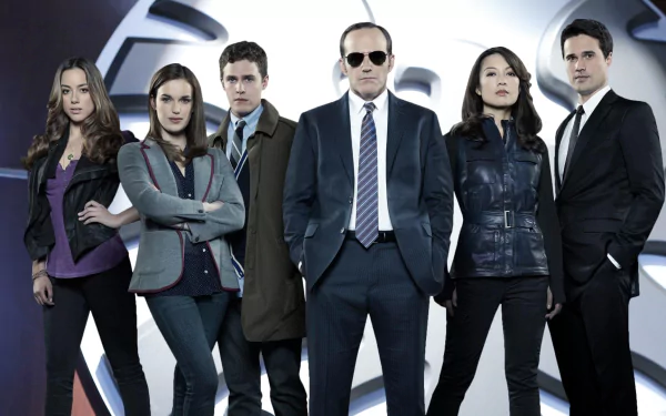 HD PC desktop wallpaper featuring the main cast of the TV show Agents of S.H.I.E.L.D. standing in front of the iconic S.H.I.E.L.D. logo.