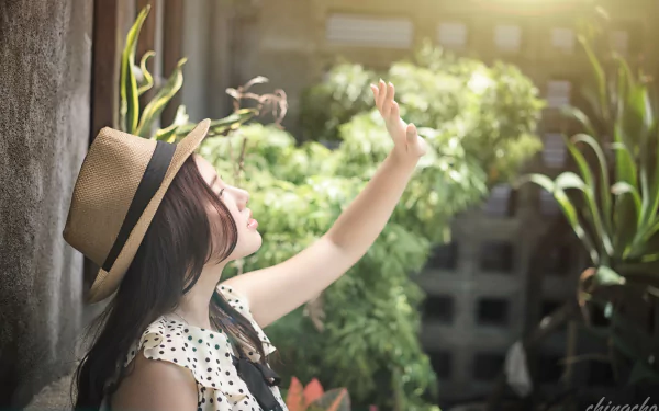 A Taiwanese Asian woman model, Chén Sīyǐng, wearing a hat reaches toward sunshine with a bokeh background in this 4K Ultra HD PC desktop wallpaper.
