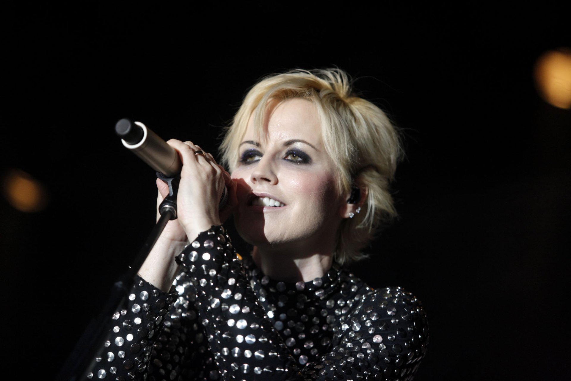 Blonde female singer in a sequined jacket singing into a microphone on stage — HD PC desktop wallpaper and music background.