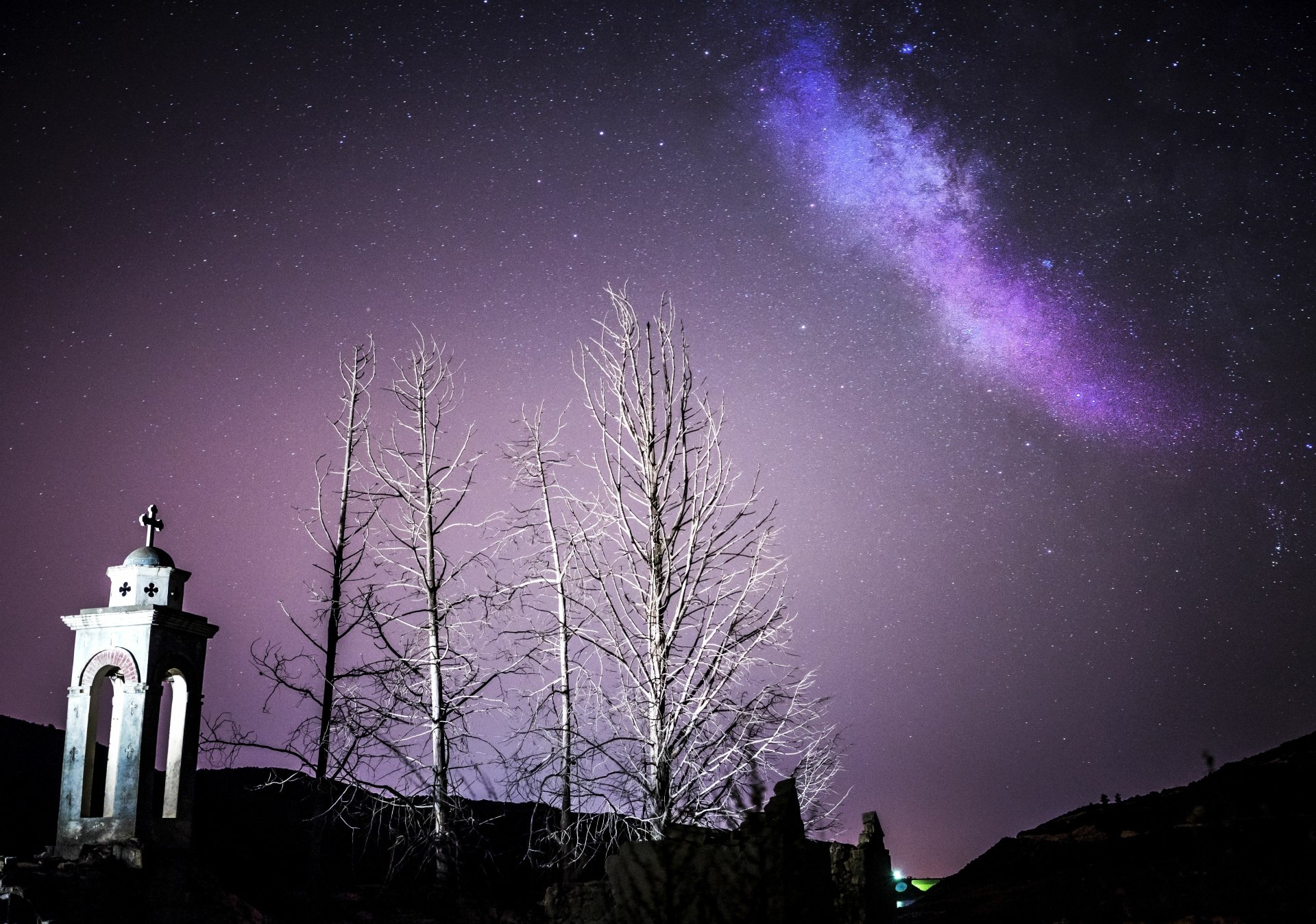 Sci‑Fi 5K Ultra HD PC desktop wallpaper/background: purple Milky Way streaks across a starry sky above bare trees and a small chapel silhouette.
