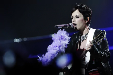 2K Quad HD PC desktop wallpaper: female rock singer performing with guitar and feathered microphone wrap under moody blue stage lighting.