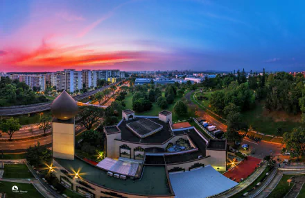 A breathtaking sunset over Singapore, featuring the Darul Makmur Mosque amidst a vibrant cityscape, capturing the essence of urban life and spirituality in stunning detail.