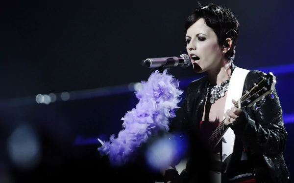 2K Quad HD PC desktop wallpaper: female rock singer performing with guitar and feathered microphone wrap under moody blue stage lighting.