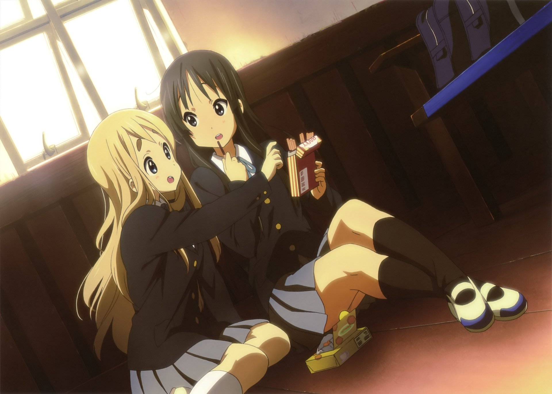 Tsumugi Kotobuki and Mio Akiyama from K-ON! sit on a sunlit classroom floor sharing snacks — 2K Quad HD PC desktop wallpaper/background.