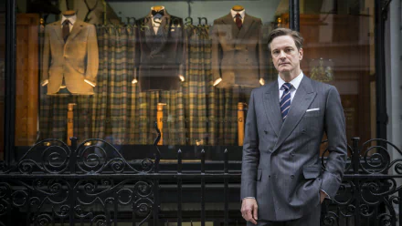 Colin Firth stands elegantly in front of a tailored suit display, capturing the stylish essence of Kingsman: The Secret Service in this HD desktop wallpaper.