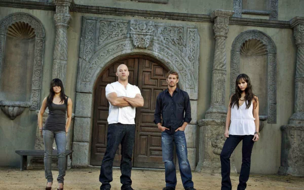The image features Mia Toretto, Letty Ortiz, Dominic Toretto, and Brian O'Conner from the movie Furious 7, set against a dramatic backdrop. An engaging HD wallpaper for fans.