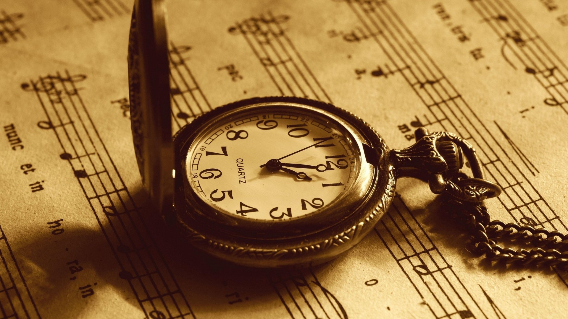4K Ultra HD man-made pocket watch resting on vintage sheet music, captured with warm sepia tones for a classic desktop wallpaper and background.
