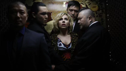 Scarlett Johansson in a tense scene from the movie Lucy, surrounded by men, featured in a 4K Ultra HD PC desktop wallpaper and background.