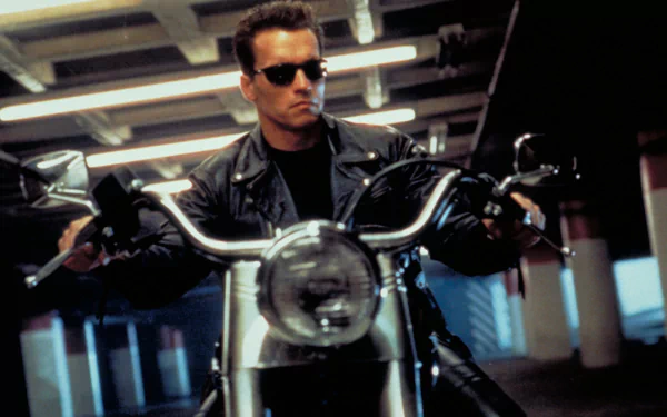 Arnold Schwarzenegger as the Terminator in a sleek black leather jacket, riding a motorcycle, captured in an iconic scene from Terminator 2: Judgment Day. HD desktop wallpaper.