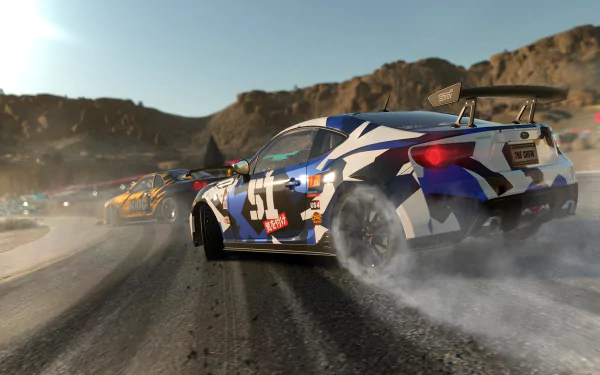 A dynamic scene from the video game The Crew, featuring race cars drifting on a dirt track with mountains in the background, showcasing high-definition graphics and action.