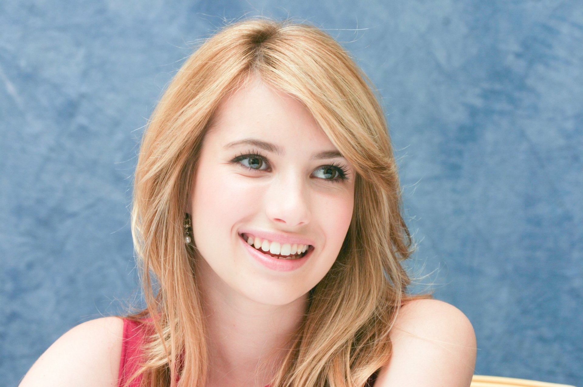 HD PC desktop wallpaper featuring a smiling celebrity Emma Roberts with blonde hair against a soft blue background.