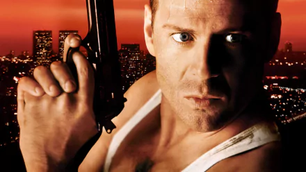 HD desktop wallpaper featuring Bruce Willis as John McClane from the movie Die Hard, set against a city skyline at sunset.