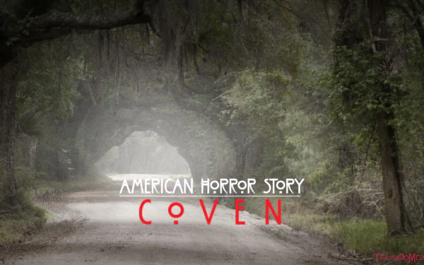 A haunting landscape from American Horror Story: Coven, featuring a misty road framed by trees, set against the show's title in striking red letters.