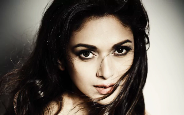 HD desktop wallpaper of celebrity Aditi Rao Hydari, featuring a close-up portrait showcasing her captivating gaze and flowing hair.