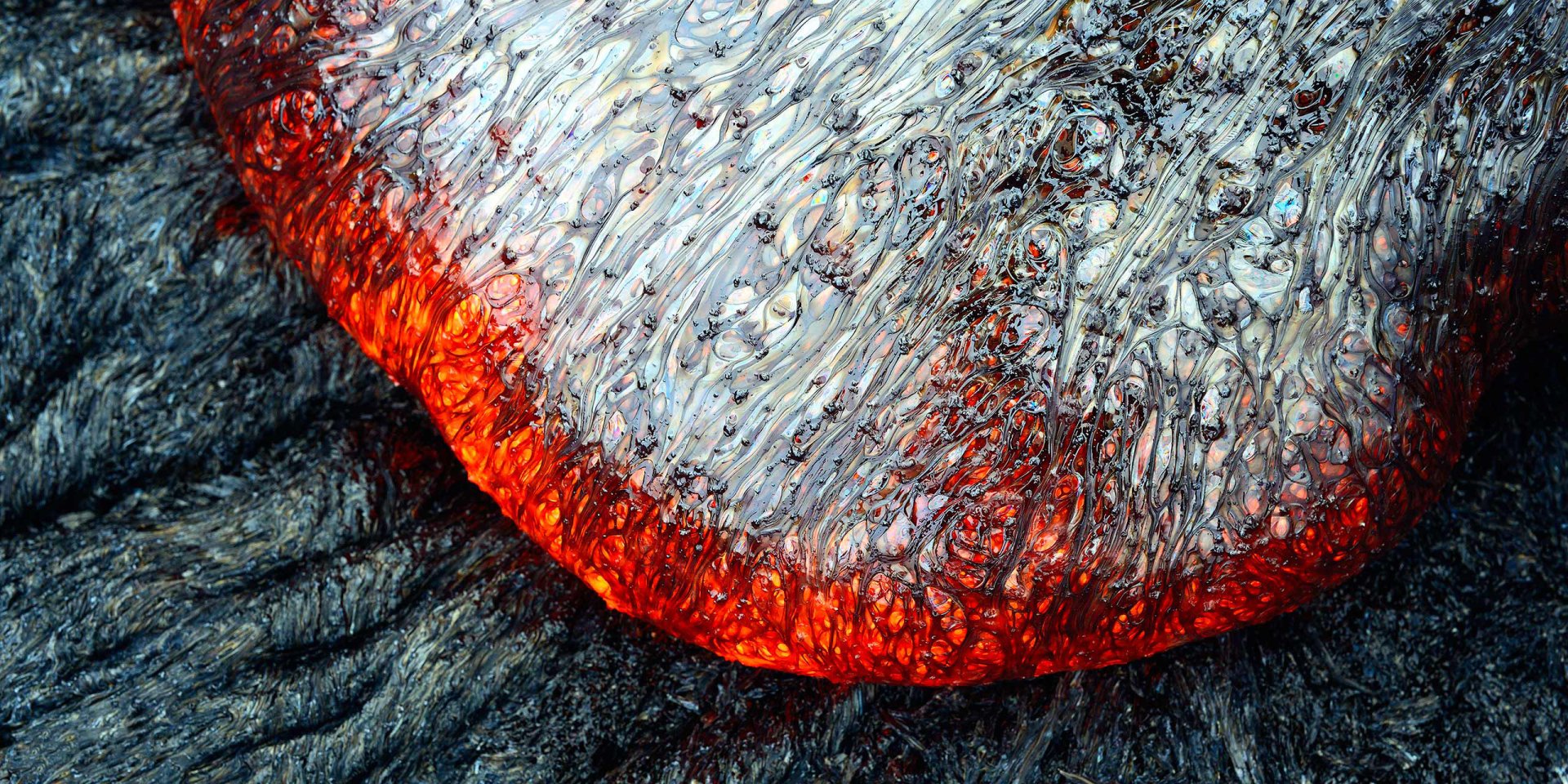 HD PC desktop wallpaper showcasing a close-up of molten lava flowing from a volcano, highlighting nature's raw power and intricate textures.