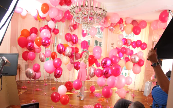 Behind-the-scenes photo of actress Emma Stone surrounded by pink and red balloons, captured in high detail for a 4K Ultra HD PC desktop wallpaper.