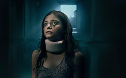 HD wallpaper of Stefanie Scott from the movie Insidious: Chapter 3, showcasing a haunting scene with her expression filled with fear and anticipation in a dark corridor.