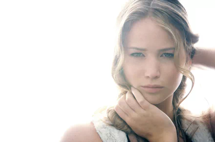 A mesmerizing HD desktop wallpaper featuring celebrity Jennifer Lawrence, showcasing her striking beauty with soft lighting and an intimate pose.