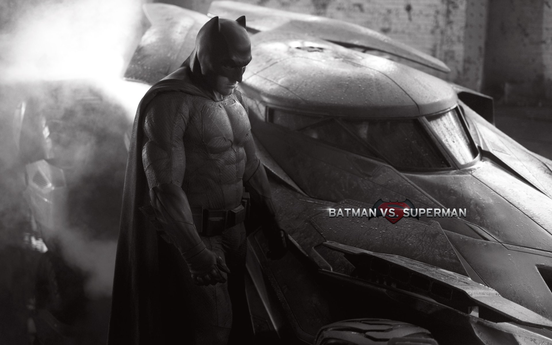A dramatic black and white HD wallpaper featuring Batman beside the Batmobile, from the movie Batman V Superman: Dawn Of Justice.