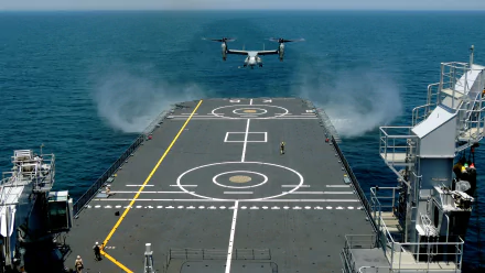 An aircraft launches from the deck of a military aircraft carrier, surrounded by blue ocean waters and showcasing impressive flight dynamics in this HD desktop wallpaper.