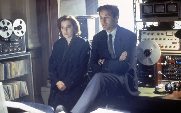 HD desktop wallpaper featuring agents from the TV show The X-Files in a dimly lit room surrounded by vintage recording equipment.