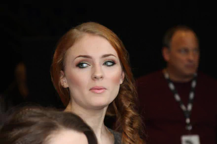 A captivating 4K Ultra HD wallpaper featuring celebrity Sophie Turner, showcasing her striking features and thoughtful expression amidst a blurred background.