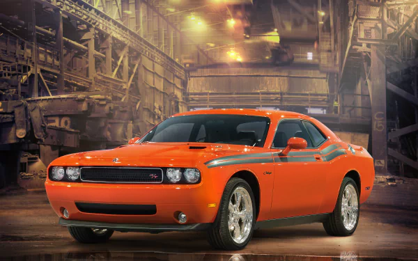 HD desktop wallpaper featuring a bright orange Dodge Challenger parked inside an industrial warehouse with warm lighting and detailed textures.