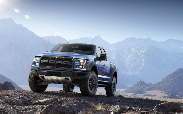 A blue Ford Raptor truck parked on rocky terrain with mountains in the background, captured in high detail for a 4K Ultra HD PC desktop wallpaper.