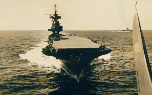 HD wallpaper of the USS Enterprise (CV-6) aircraft carrier warship cutting through the ocean, showcasing its military power and naval design.