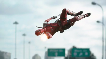 A dynamic HD desktop wallpaper featuring Deadpool in mid-air, firing his weapon against a city backdrop, capturing the action-packed essence of the movie.