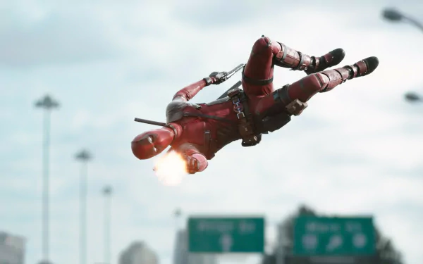 A dynamic HD desktop wallpaper featuring Deadpool in mid-air, firing his weapon against a city backdrop, capturing the action-packed essence of the movie.