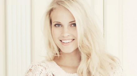 HD PC desktop wallpaper featuring a smiling woman with long blonde hair, identified as Emilie Marie Nereng, against a light, softly blurred background.