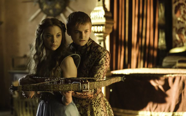 Jack Gleeson as Joffrey Baratheon stands behind Natalie Dormer as Margaery Tyrell in a dramatic scene from the TV show Game of Thrones, shown in HD desktop wallpaper quality.