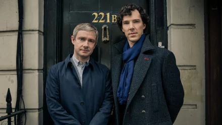 Two characters from the TV show Sherlock stand outside the famous 221B Baker Street door, featuring a close-up of their expressions in a stylish HD desktop wallpaper.