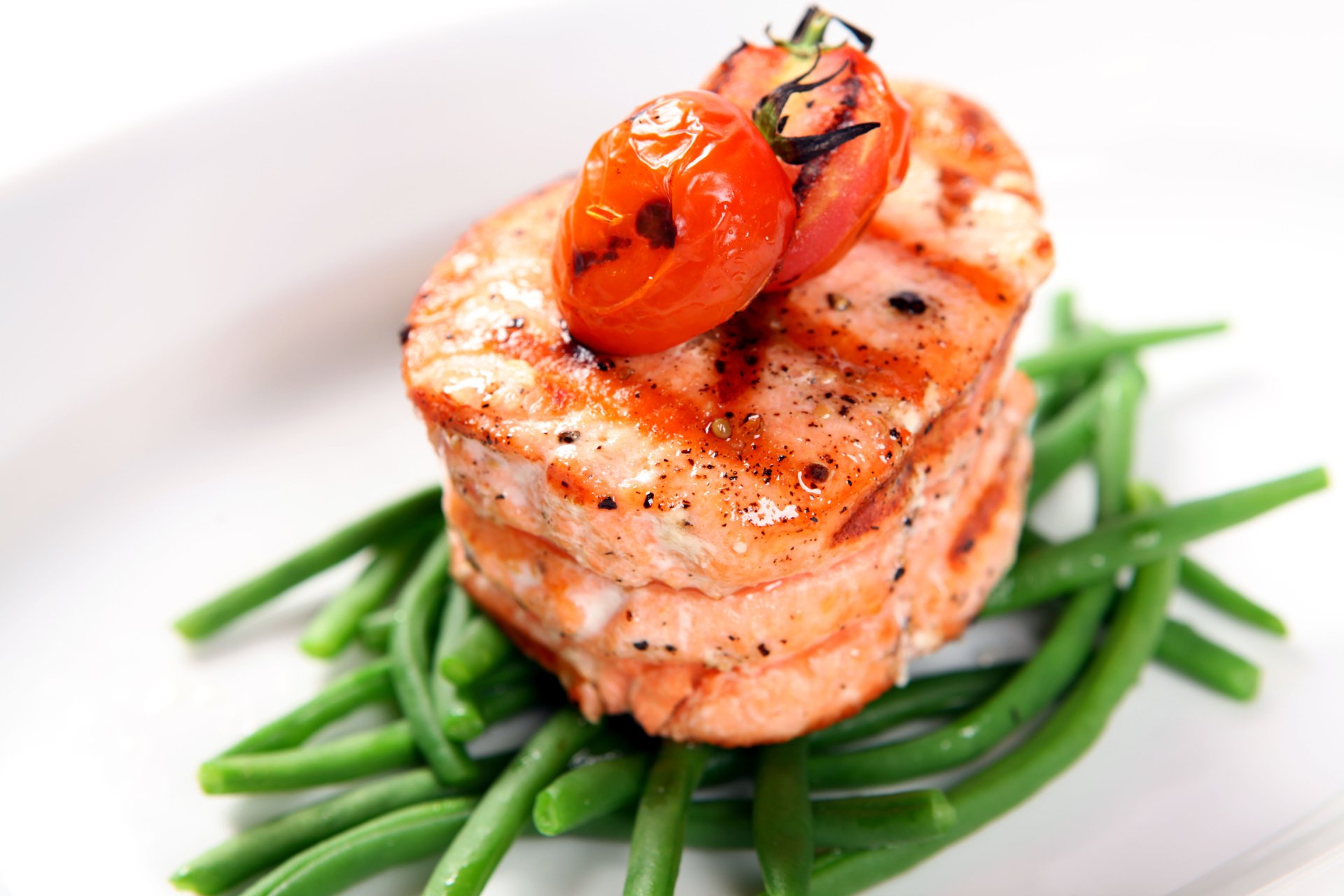 5K Ultra HD PC desktop wallpaper and background: grilled salmon medallions stacked on green beans, topped with a roasted cherry tomato on a white plate.