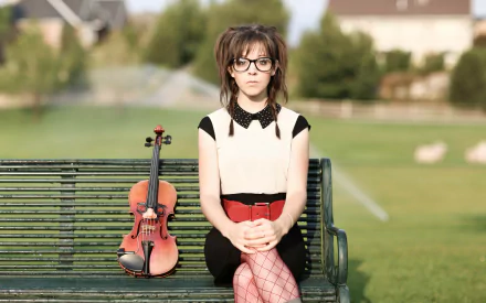 2K Quad HD PC desktop wallpaper and background — music-themed portrait of a female violinist seated on a park bench with her violin at her side, soft green lawn behind her.