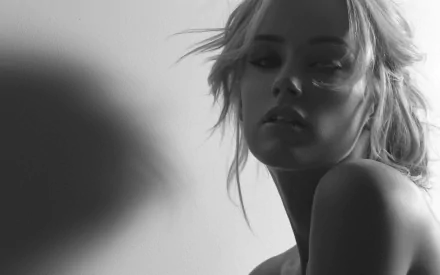 A striking black-and-white HD wallpaper featuring celebrity Amber Heard, showcasing her in a contemplative pose with soft lighting highlighting her features.