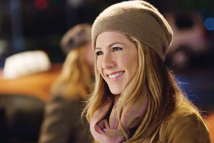 HD desktop wallpaper featuring Jennifer Aniston smiling, from the movie Love Happens, with a softly blurred evening background.