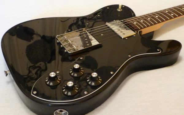 Close-up of a glossy black electric guitar on a light surface, detailed strings and knobs — 4K Ultra HD PC desktop wallpaper background, music-themed.