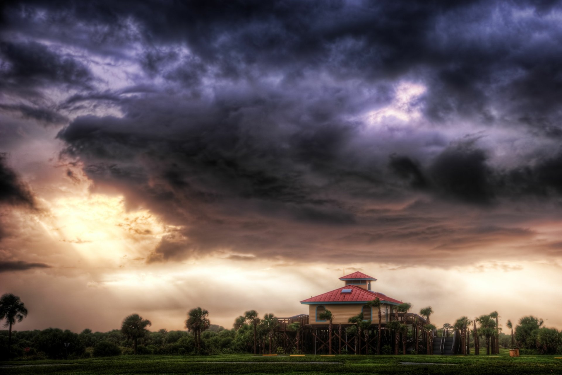 2K Quad HD PC desktop wallpaper: nature, storm — dramatic dark clouds and light breaking over a lone pavilion on a grassy plain.