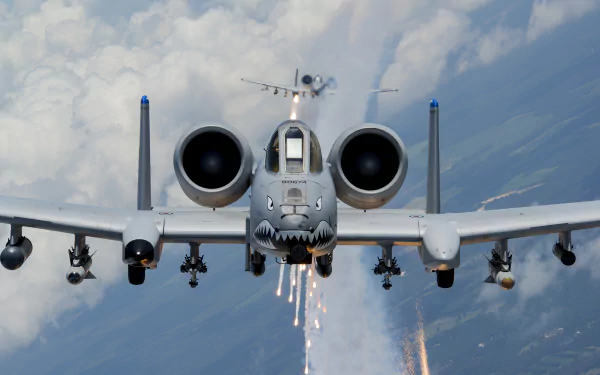 HD desktop wallpaper showcasing a Fairchild Republic A-10 Thunderbolt II aircraft in flight, firing flares against a cloudy sky backdrop, highlighting its military design.