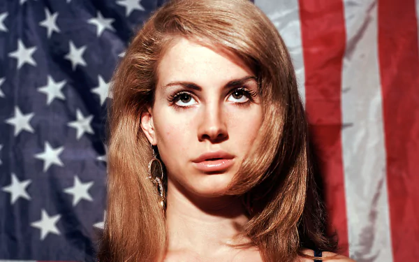 HD PC desktop wallpaper featuring a close-up of Lana Del Rey with the American flag in the background, highlighting her iconic music persona.