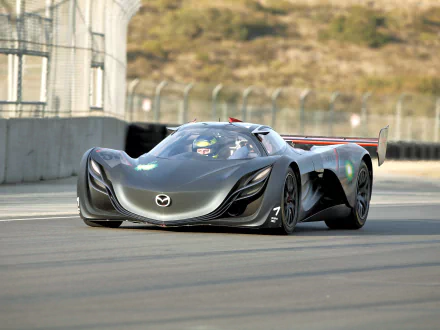 HD PC desktop wallpaper featuring a sleek black Mazda Furai race car speeding on a track with blurred background and detailed aerodynamic design.