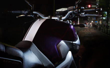 Close-up night shot of a Yamaha MT-09 motorcycle tank and handlebars with neon reflections and high-contrast details — HD PC desktop wallpaper/background.