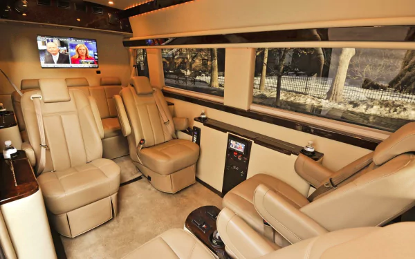 Luxury Mercedes‑Benz Sprinter van interior with beige leather captain chairs, wood trim, infotainment screens and wide windows — HD PC desktop wallpaper background.