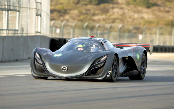 HD PC desktop wallpaper featuring a sleek black Mazda Furai race car speeding on a track with blurred background and detailed aerodynamic design.