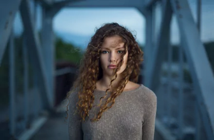 Close-up portrait of a brunette woman with curly hair and blue eyes, captured in 4K Ultra HD as a PC desktop wallpaper.