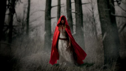 Movie HD PC desktop wallpaper: Red Riding Hood — cloaked woman in a red hooded cloak walks through foggy, bare winter woods.