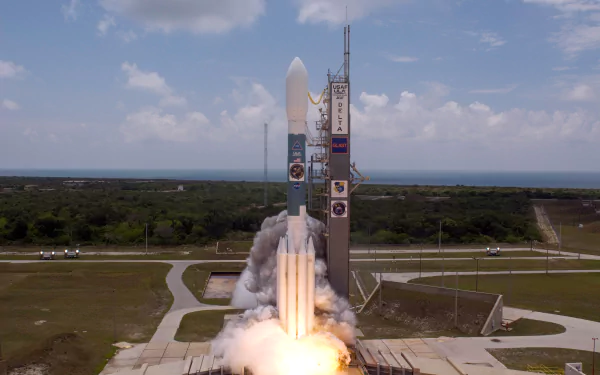 Delta II rocket launches from Cape Canaveral, NASA site, captured in HD as it ascends with bright flames and smoke against a partly cloudy sky.